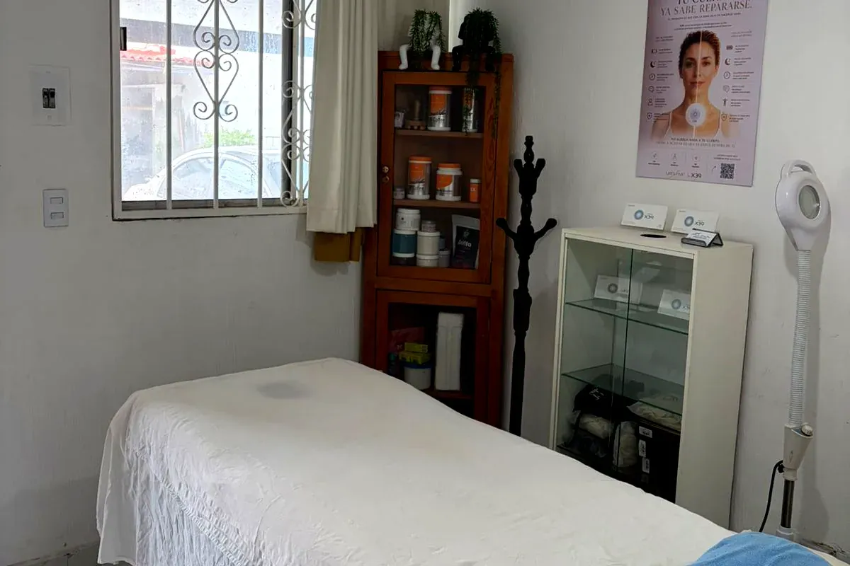 Cabina de masaje de Spacio Azul en Zapopan, con camilla preparada, vitrina de productos y lámpara de aumento